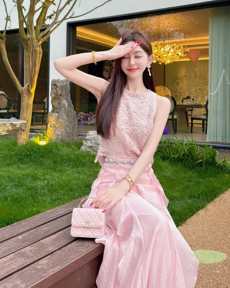 cô gái mặc váy hồng dài đứng giữa nắng